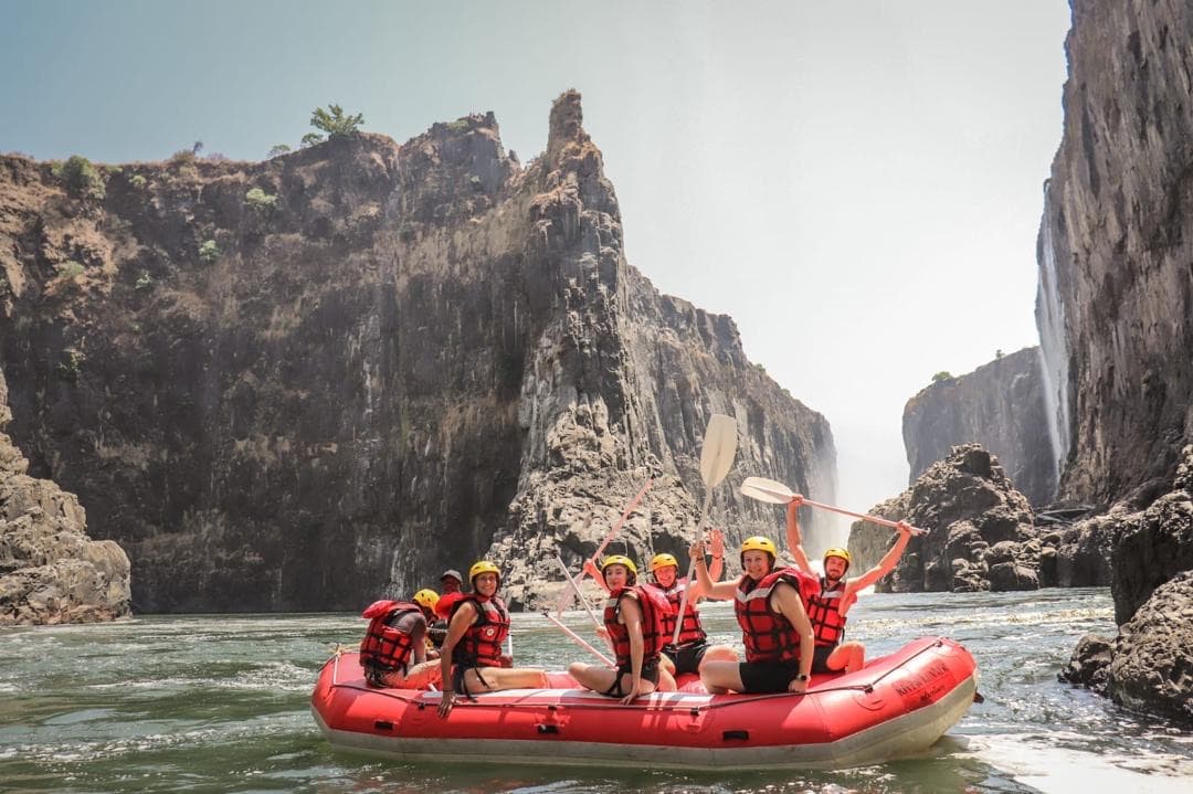A happy group raising their paddles in the Batoka Gorge